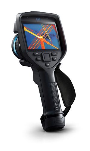 La caméra thermique FLIR E96 vue de face avec une image thermique sur l'écran. Une dragonne est attachée à la caméra sur la droite.